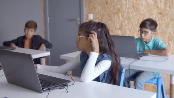 Menina pensativa em óculos sentado na mesa com laptop — Vídeo de Stock