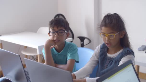 Dos compañeros de clase emocionados en gafas colaborando en el proyecto — Vídeo de stock