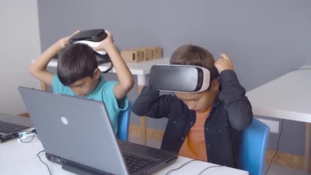 Due compagni di classe indossano occhiali VR alla scrivania — Video Stock