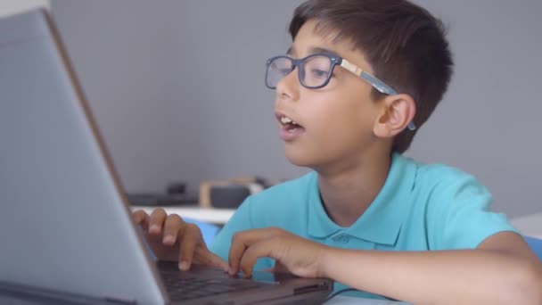 Gericht schooljongen zitten aan het bureau in de klas — Stockvideo