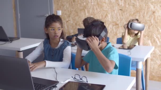 Возбужденные школьники надевают наушники VR — стоковое видео