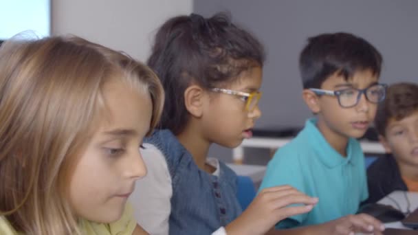 Chytrý školák v brýlích pomáhá spolužáky dělat úkol — Stock video