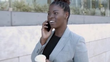 Mutlu Afrikalı Amerikalı iş kadını dışarıda yürüyor