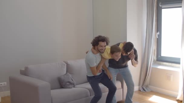 Feliz hijo y sus dos padres disfrutando de la actividad en casa — Vídeo de stock