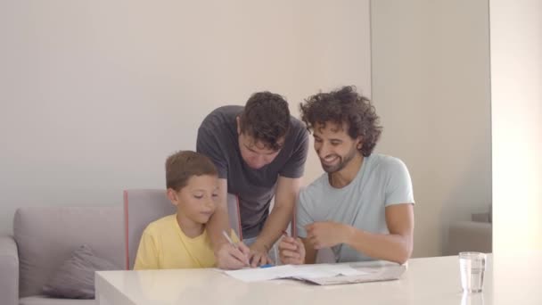 Otcové pomáhají synovi s úkolem psaní — Stock video