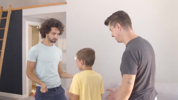 Vrolijke gay ouders onderwijzen zoon naar dansen thuis — Stockvideo