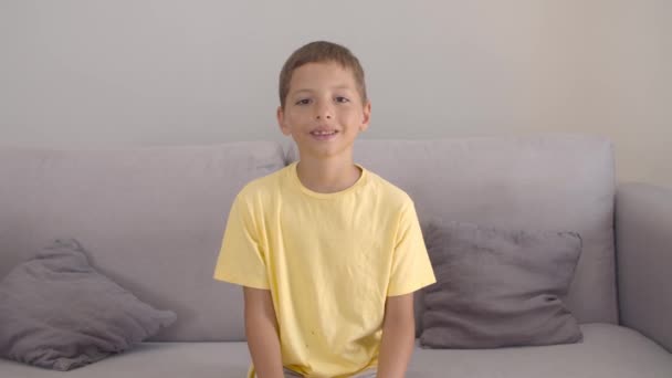 Vidám, pozitív fiú sárga pólóban. — Stock videók