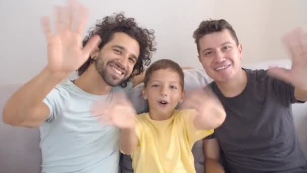 Két boldog apuka és egy gyerek integet a kamerának. — Stock videók