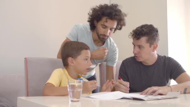 Homosexuální rodiče pomáhají synovi s úkolem psaní — Stock video