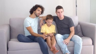 Evde film izleyen iki baba ve oğul.