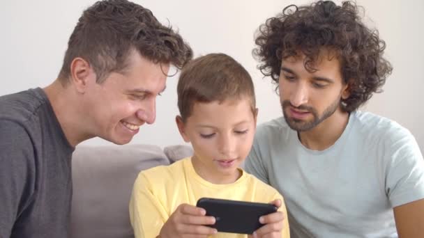 Garçon excité jouer à un jeu en ligne sur smartphone — Video