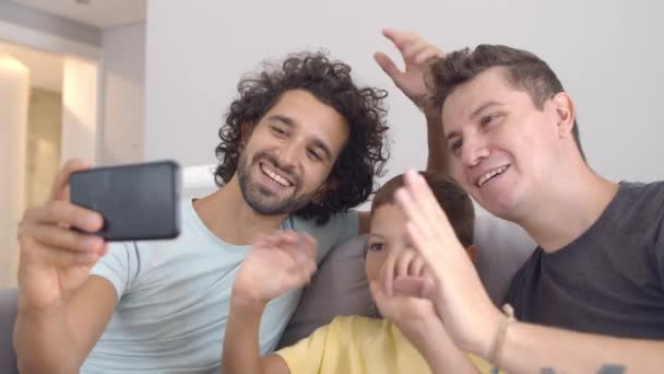 Positieve homoseksuele ouders en kind met behulp van mobiele telefoon voor videogesprek — Stockvideo