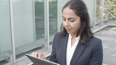 Düşünceli genç iş kadını tablet üzerinde online uygulama kullanıyor