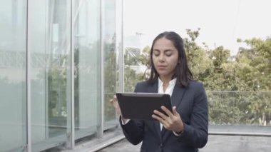 Tablet kullanan takım elbiseli Latin iş kadını