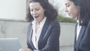 Dost canlısı bayan meslektaşlar dışarıda oturuyor.