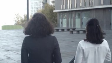 İş yerinden ayrılan ve konuşan kadın meslektaşların arka plan görüntüsü