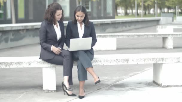 Experienced businesswomen sitting outdoors with laptop — Stock Video