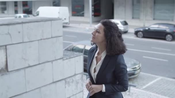 Серйозна кавказька бізнес-леді в костюмі ходити нагорі. — стокове відео