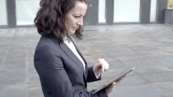 Investidora experiente assistindo dados financeiros via tablet — Vídeo de Stock