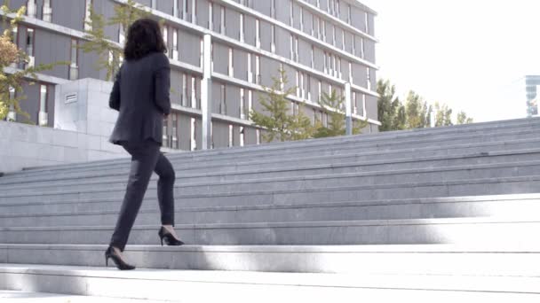 Успішна кучерява бізнес-леді йде нагору — стокове відео