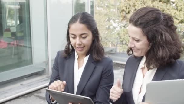 Compañeras de negocios alegres usando tableta — Vídeo de stock