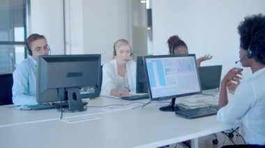 Ofiste çalışan kulaklıklı bir grup finans komisyoncusu.