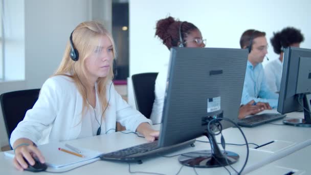 Row of call center operators using computers — Video