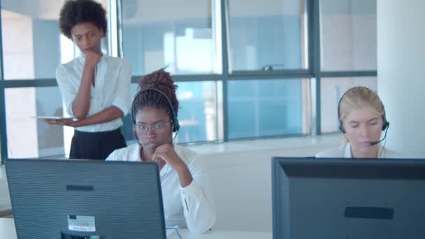 Vrouwelijke call center mentor en operators in headsets — Stockvideo