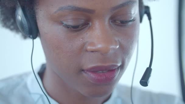 Tvář afroamerického zaměstnance call centra ve sluchátkách — Stock video