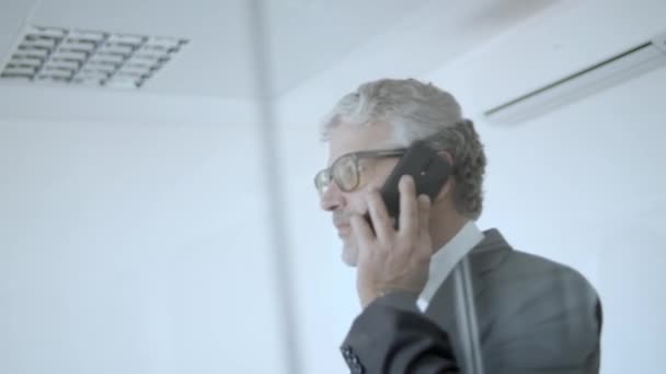 Skoncentrowany dojrzały lider biznesu spaceru w jego biurze — Wideo stockowe
