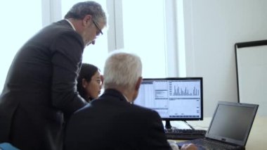 Borsa istatistiklerini incelemekle meşgul tüccarlar