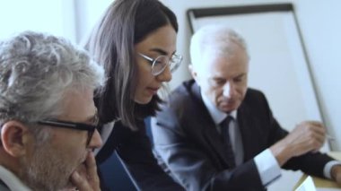 Dosyaları açıklayan genç bir kadın finans uzmanı.