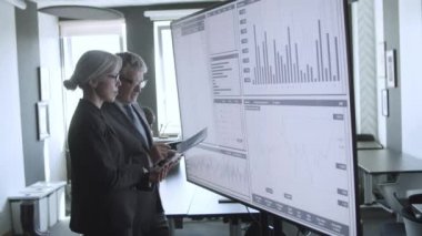 Finansal uzmanlar birlikte çalışıyor ve ticaret grafiklerini analiz ediyorlar.