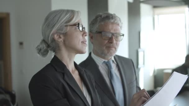 Deux chefs d'entreprise ciblés lisant et analysant des documents — Video