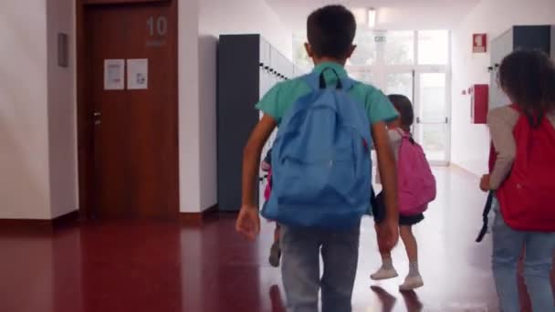 Schoolkinderen van verschillende leeftijden verlaten de school — Stockvideo