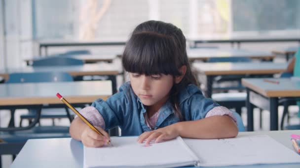 Zaměřená žákyně základní školy drží tužku — Stock video