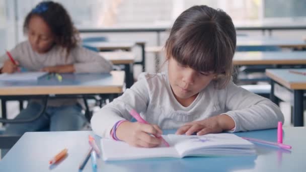 Studentessa primaria latina focalizzata usando un pennarello colorato — Video Stock