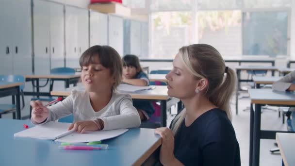 Profesora de escuela primaria ayudando a colegiala latina — Vídeo de stock