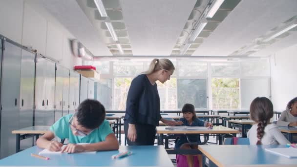 机の間を歩く女子校教師 — ストック動画