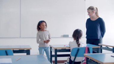 Dost canlısı öğretmen yarış öğrencilerini karıştırmaya yardım ediyor.