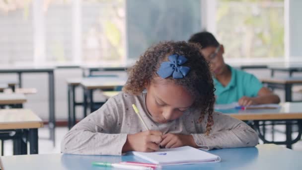 Gericht zwart basisschool student meisje met behulp van pen — Stockvideo