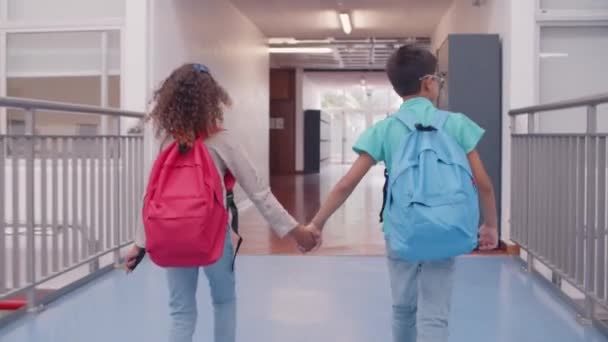 Různorodý pár školáků opouští školu — Stock video