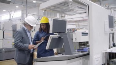 Siyahi kadın endüstriyel profesyonel kontrol panelinde duruyor