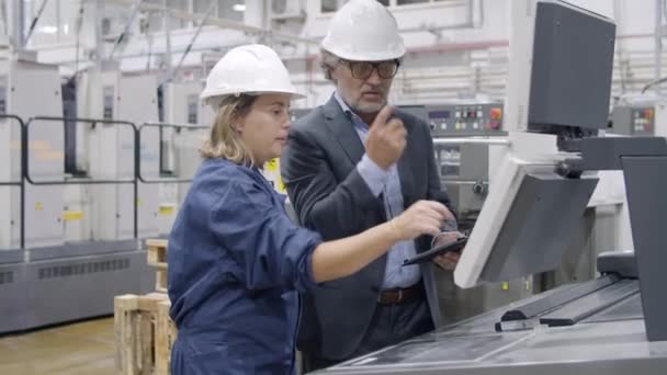 Älterer Ingenieur lehrt Fabrikangestellte, neue Maschine zu bedienen — Stockvideo
