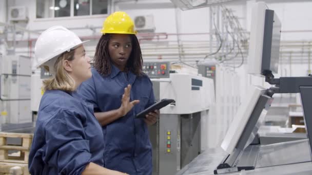 Diverse Fabrikarbeiterinnen diskutieren über Maschine — Stockvideo