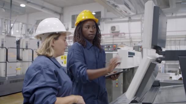 Μαύρο θηλυκό εργοστάσιο μέντορας δείχνει μηχανή — Αρχείο Βίντεο