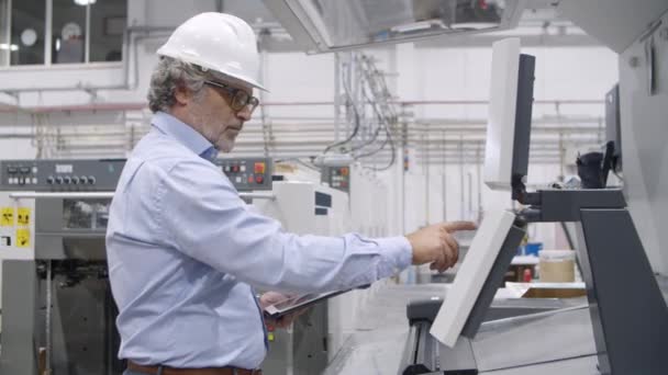 Ingeniero sénior probando máquina industrial — Vídeo de stock