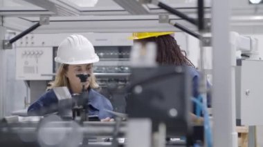 Siyahi kadın fabrika mühendisi orta yaşlı çalışanlara ders veriyor