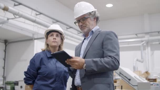 Engenheiro mais velho usando tablet e mostrando processo de trabalho de máquinas — Vídeo de Stock