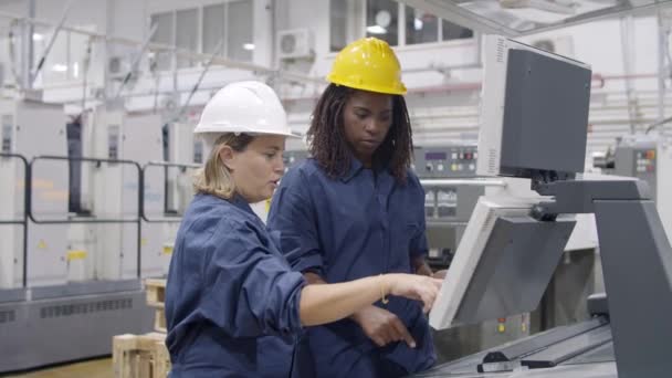 Diversas empleadas de fábrica estudiando nueva máquina — Vídeos de Stock